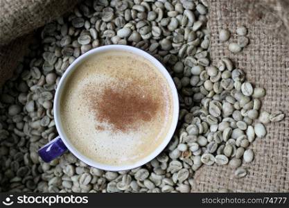 cup of hot coffee on coffee beans