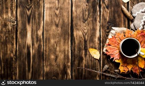 Cup of hot coffee with autumn leaves. On wooden background.. Cup of hot coffee with autumn leaves.