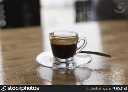 cup of hot espresso coffee shot on wooden table