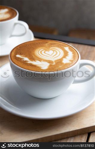 cup of hot latte art coffee on wooden table
