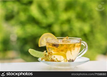 Cup of hot tea with sacking on the wooden table and the tea plantations background. Cup of hot tea with sackingCup of hot tea with sacking on the wooden table