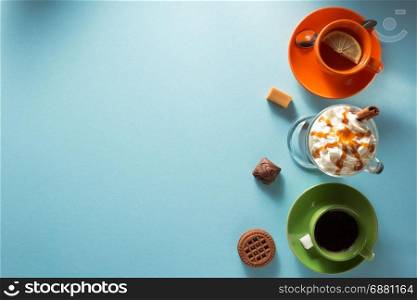 cup of ice cream coffee, tea and cacao at blue paper background