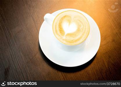 Cup of latte coffee with heart symbol