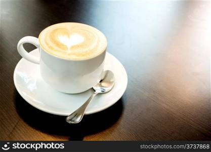 Cup of latte coffee with heart symbol