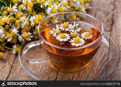 Cup of medicinal chamomile tea. Cup of medicinal chamomile tea on a wooden