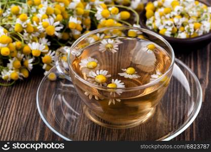 Cup of medicinal chamomile tea. Cup of medicinal chamomile tea on a wooden