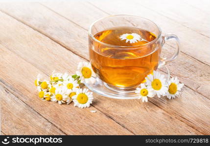 Cup of medicinal chamomile tea on a wooden