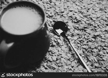 Cup of oat milk with a hand grabbing it, in a moody tones in a cozy cup with copy space