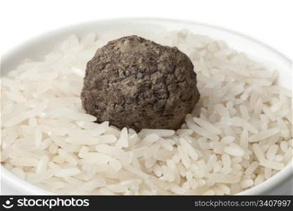 Cup of raw rice with fresh black winter truffle truffle close up on white background