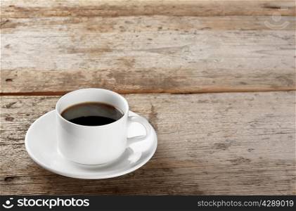 Cup of strong black coffee on a wooden background