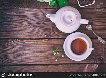 cup of tea and a brewer on a brown wooden background, top view, empty space on the left