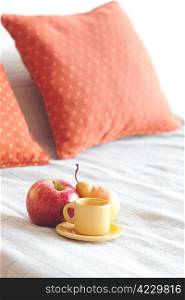 cup of tea,apple and pear on the bed