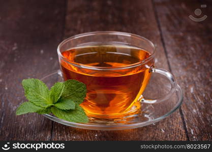 Cup of tea. Cup of tea and mint on a wooden background