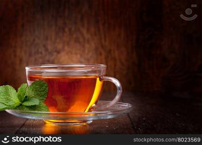 Cup of tea. Cup of tea and mint on a wooden background