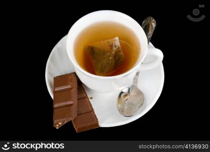 Cup of tea drink with chocolate over black background