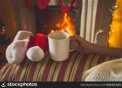 Cup of tea on sofa at fireplace