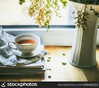 Cup of tea on window still with vase and flowers. Summer still life. Cozy home scene