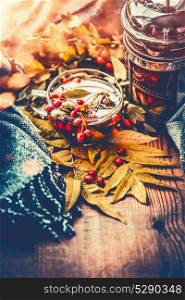 Cup of tea with autumn berries , leaves and scarf