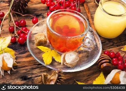 cup of tea with autumn leaves. cup tea with mulberry on background with autumn leaves.Autumn still life