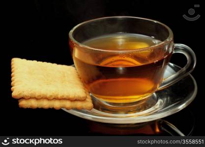 Cup of tea with biscuits on black background