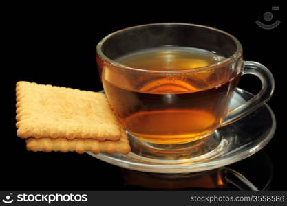 Cup of tea with biscuits on black background