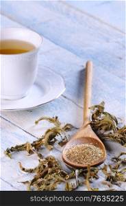 Cup of tea with herbal tea on wooden table.&#xA;