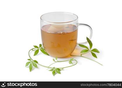 Cup of tea with jiaogulan herb on white background