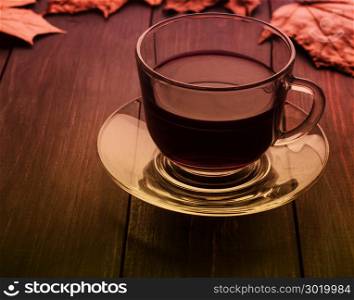 Cup of tea with leaves on a black table in an instagram.