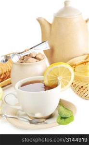 cup of tea with lemon and cookies in basket