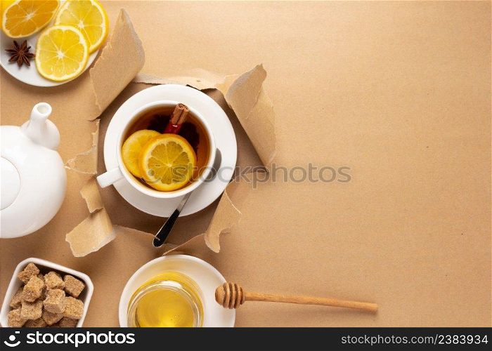 Cup of tea with lemon and honey in torn paper. Mug full green tea