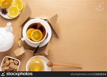 Cup of tea with lemon and honey in torn paper. Mug full green tea