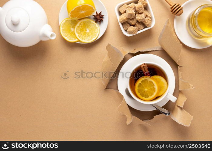 Cup of tea with lemon and honey in torn paper. Mug full green tea