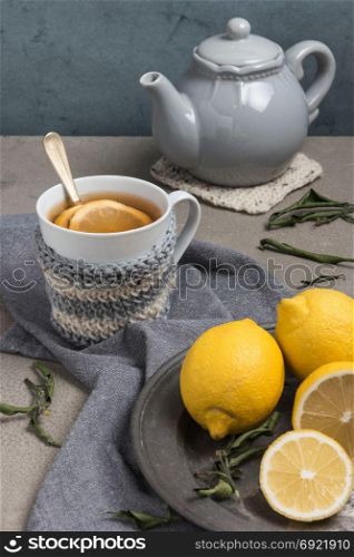 Cup of tea with lemon on table close-up. Healthcare traditional medicine and flu concept - tea cup with lemon. Hot tea with lemon treatment of colds flu and runny.