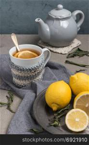 Cup of tea with lemon on table close-up. Healthcare traditional medicine and flu concept - tea cup with lemon. Hot tea with lemon treatment of colds flu and runny.