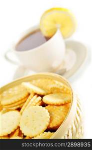cup of tea with lemon, pastry and cookies in basket