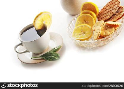 cup of tea with lemon, pastry and sugar