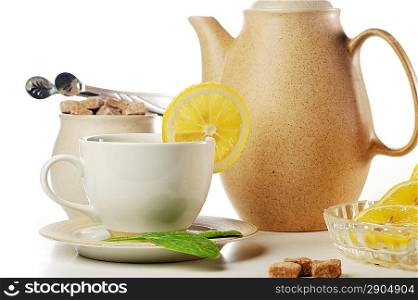 cup of tea with lemon, pastry and teapot