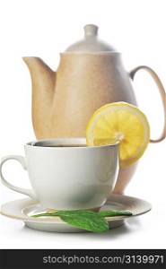 cup of tea with lemon, pastry and teapot