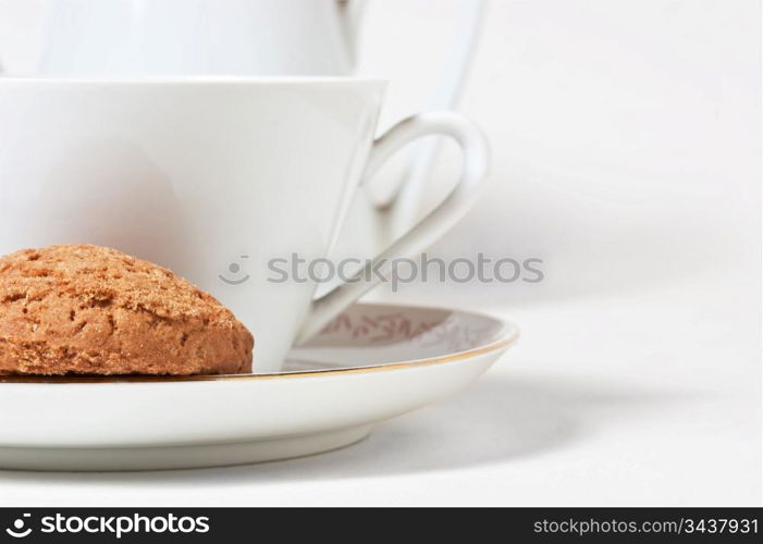 cup on a saucer and biscuits