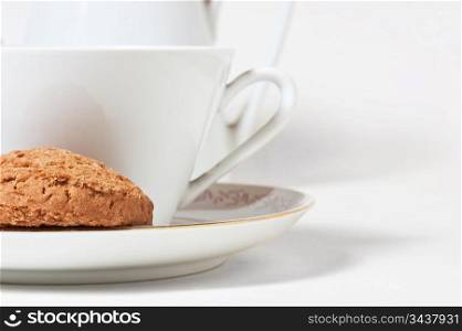 cup on a saucer and biscuits