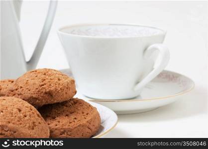 cup on a saucer and biscuits