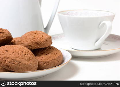 cup on a saucer and biscuits