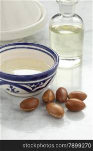Cup with argan oil and nuts for cosmetics