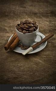 cup with beans cigar and cinnamon