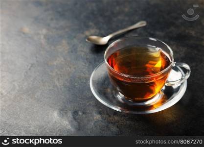 Cup with black tea on rustic metal background