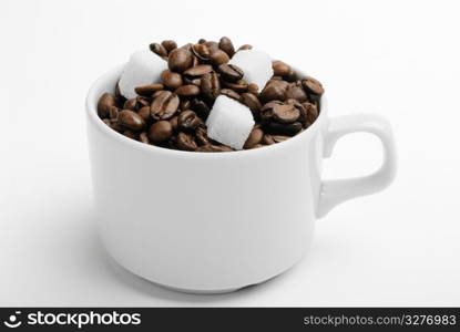 cup with coffee beans and sugar. closeup