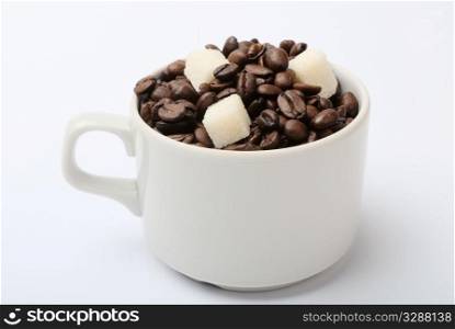 cup with coffee beans and sugar. closeup