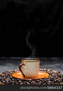 Cup with coffee espresso arranged on a dark background. Roasted coffee beans are located around a cup of coffee.Close up, selective focus