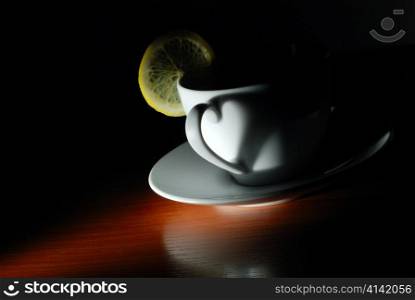 cup with lemon in dark