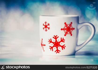 Cup with snowflakes on winter bokeh background, front view